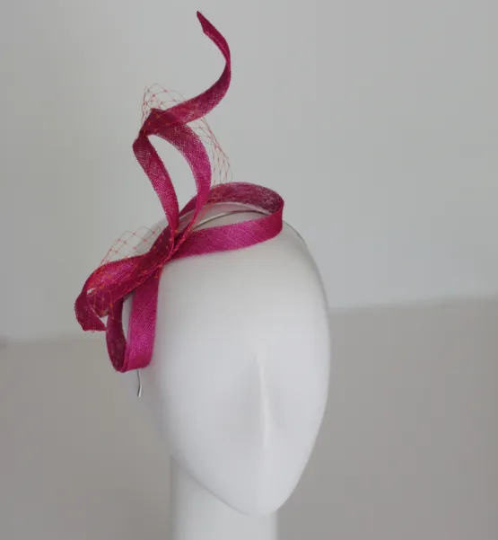 Wijący się fascynator w kolorze fuksji z woalką