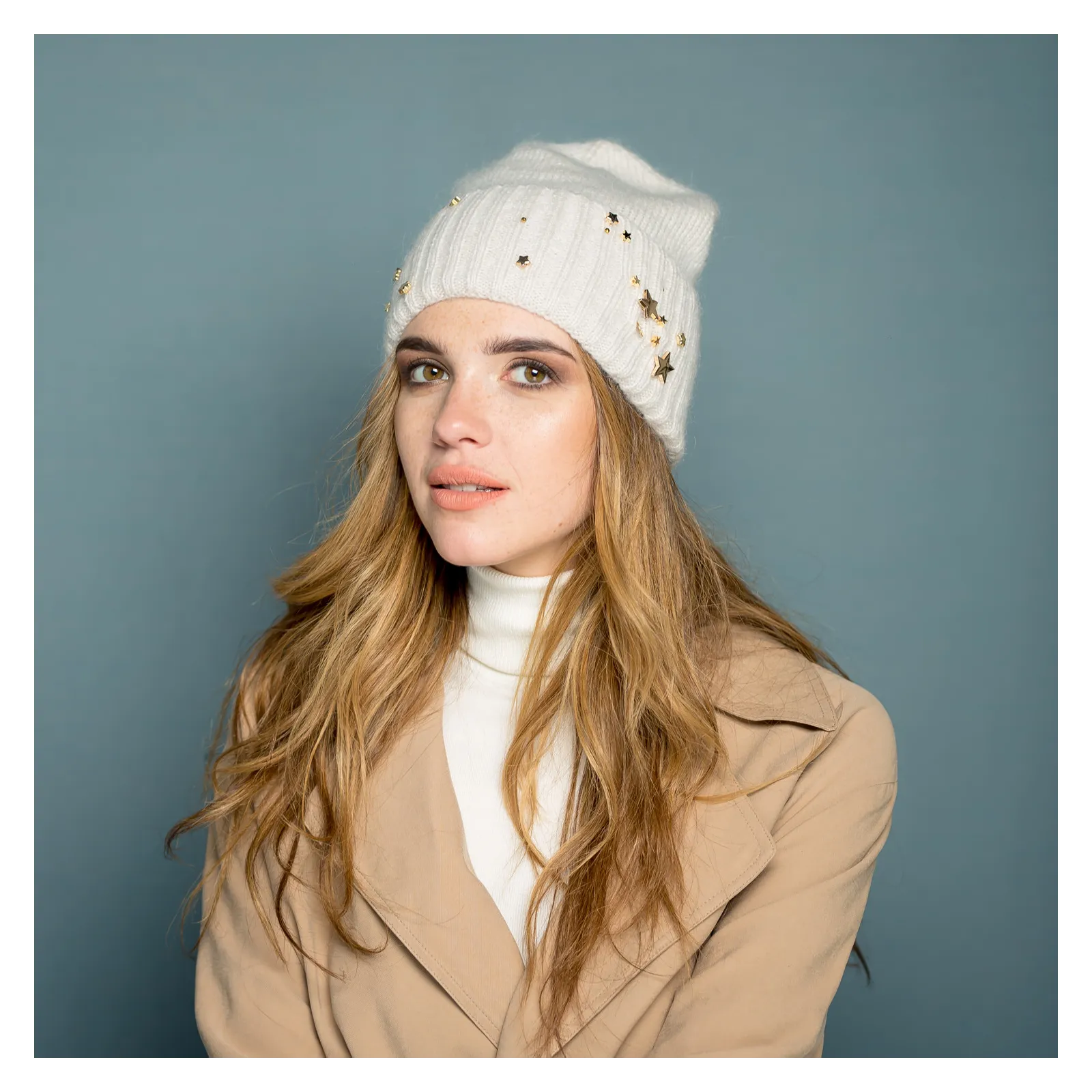 Kremowa moherowa czapka na zimę ze złotą ozdobą.