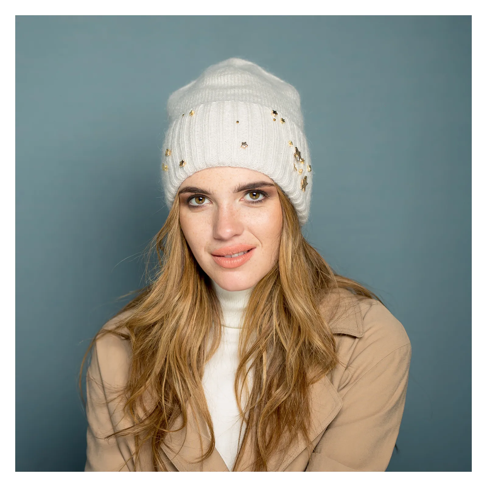 Kremowa moherowa czapka na zimę ze złotą ozdobą.