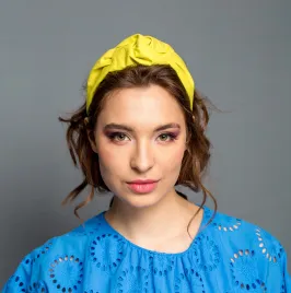 Sztywna opaska do włosów w żółtym kolorze.