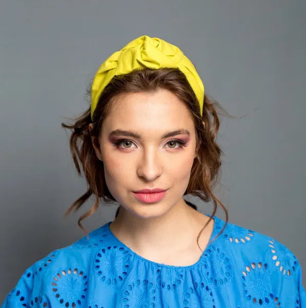 Sztywna opaska do włosów w żółtym kolorze.