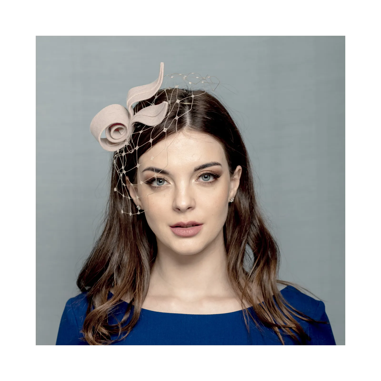 Beżowy filcowy fascynator inspirowany kwiatem.