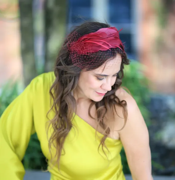 Wiśniowy fascynator z piór z woalką.