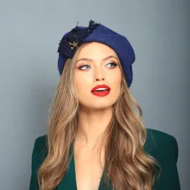 Niebieski beret z tweedową kokardą i z ozdobami.