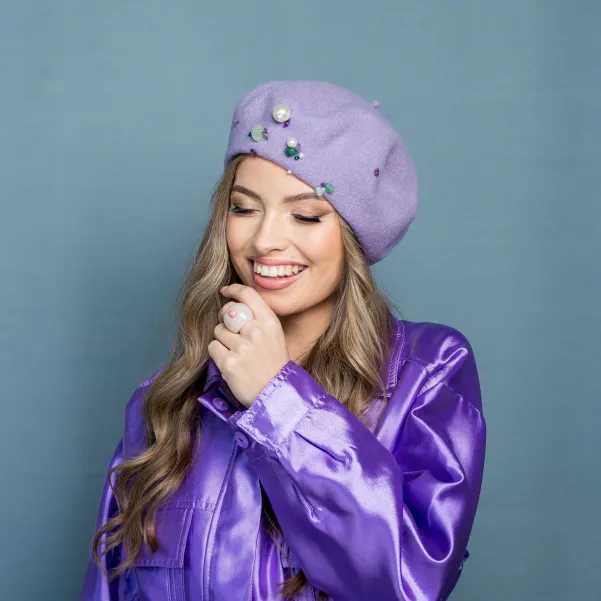 Liliowy beret zdobiony kolorowymi kamieniami.