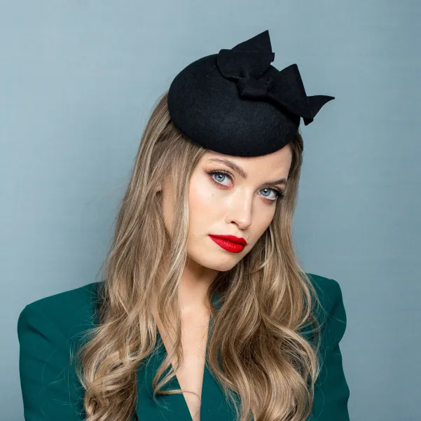 Czarne eleganckie nakrycie głowy kokardą.