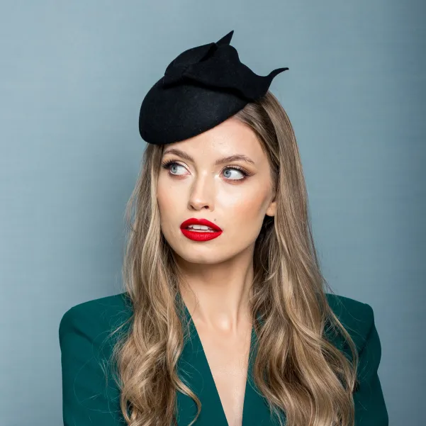 Czarne eleganckie nakrycie głowy kokardą.