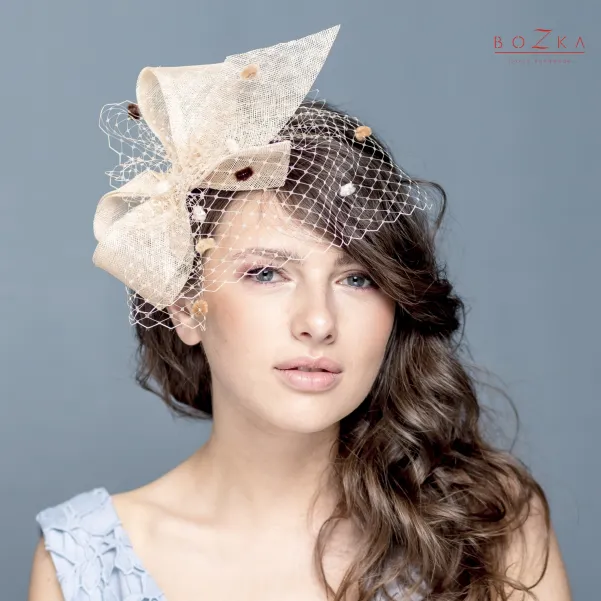 Beżowy opaska z dużą kokardą i woalką.