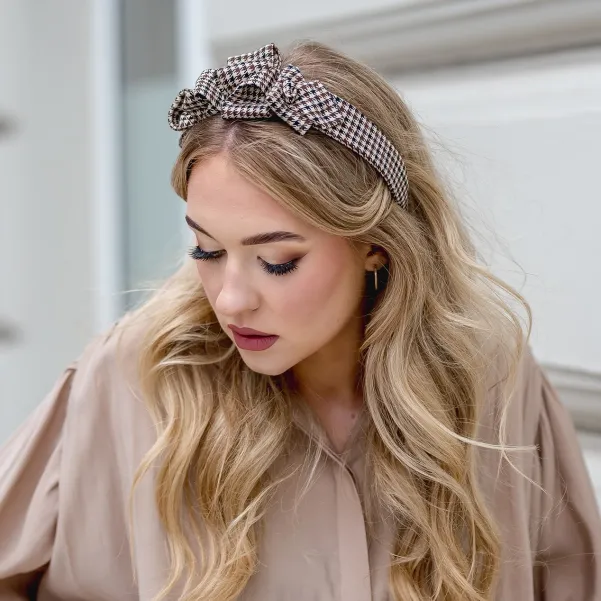 Twarzowa opaska w beżową pepitkę z ozdobą.