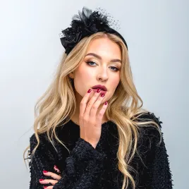 Czarna aksamitna opaska z dużą ozdobą.