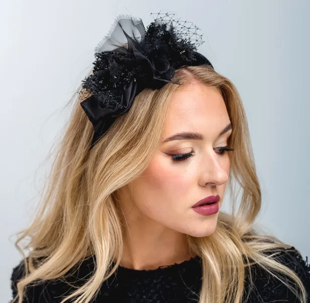 Czarna aksamitna opaska z dużą ozdobą.