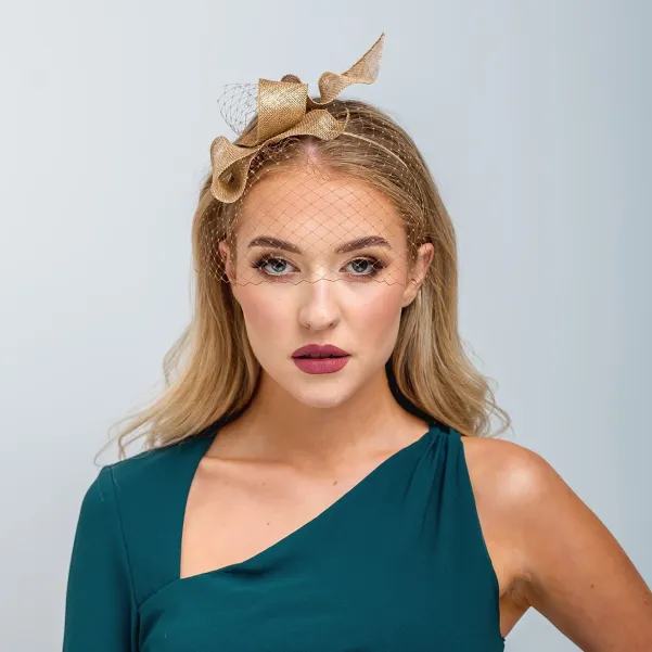 Złoty fascynator falująca kokarda z woalką.