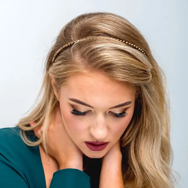 Delikatna złota błyszcząca opaska do włosów.