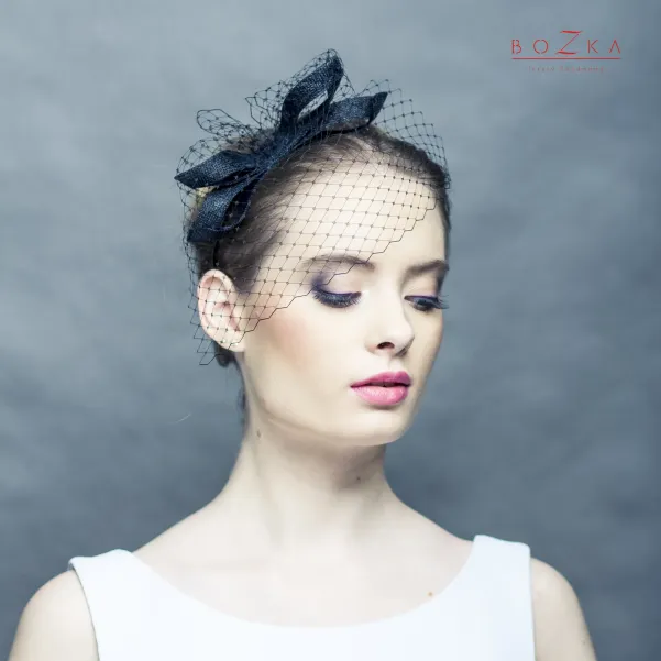 Czarny fascynator z kokardą i z woalką.