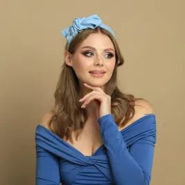 Błękitna opaska kobieca z kokardą z boku.