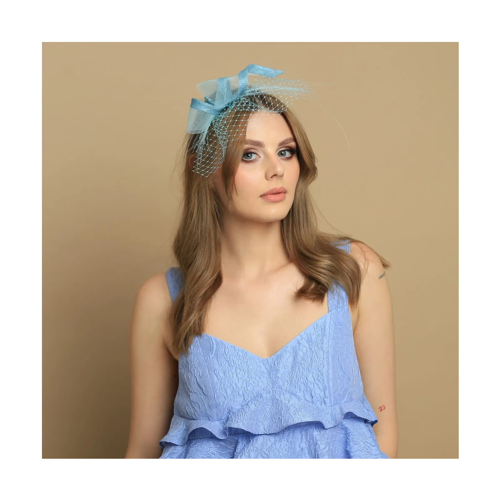 Turkusowy fascynator z woalką.