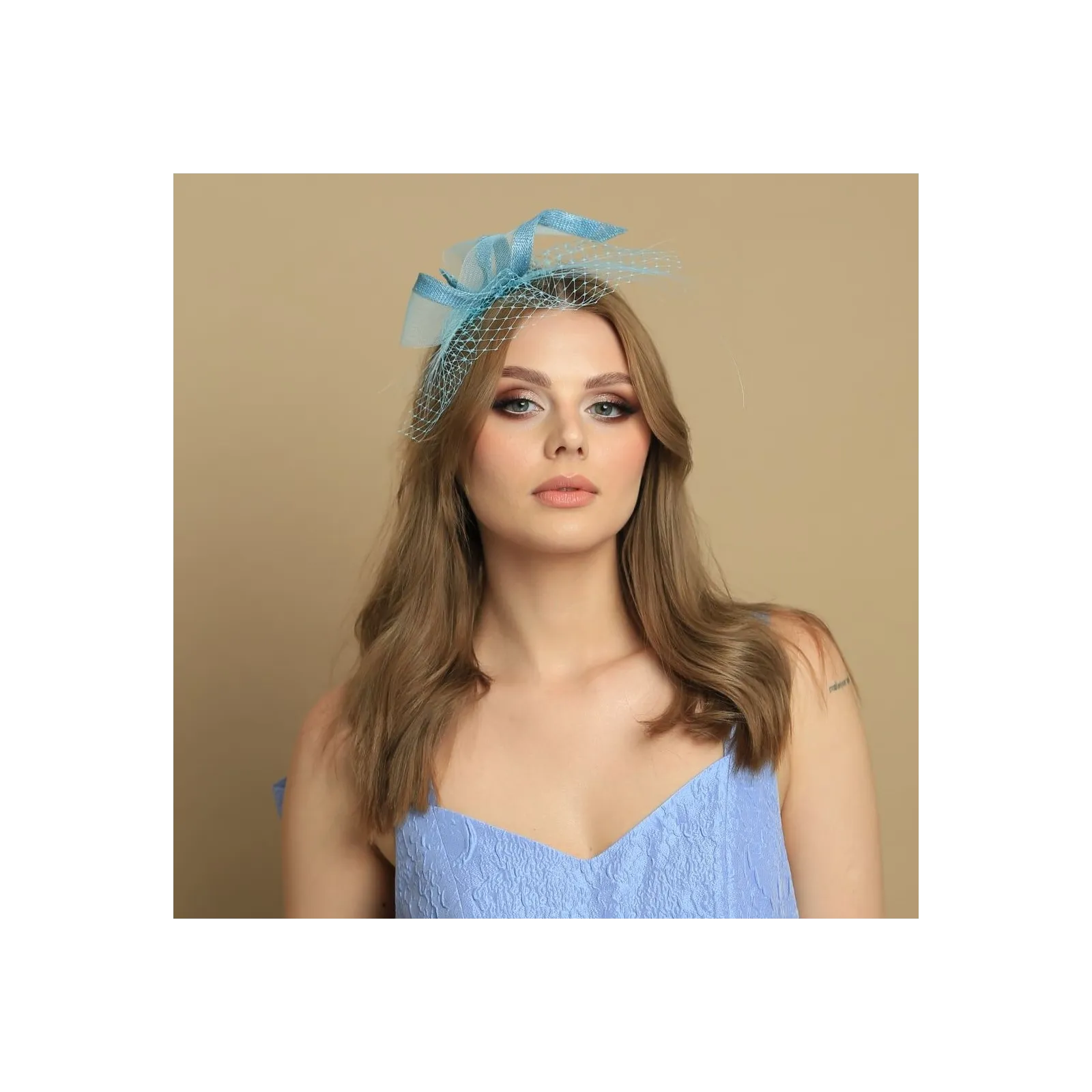Turkusowy fascynator z woalką.
