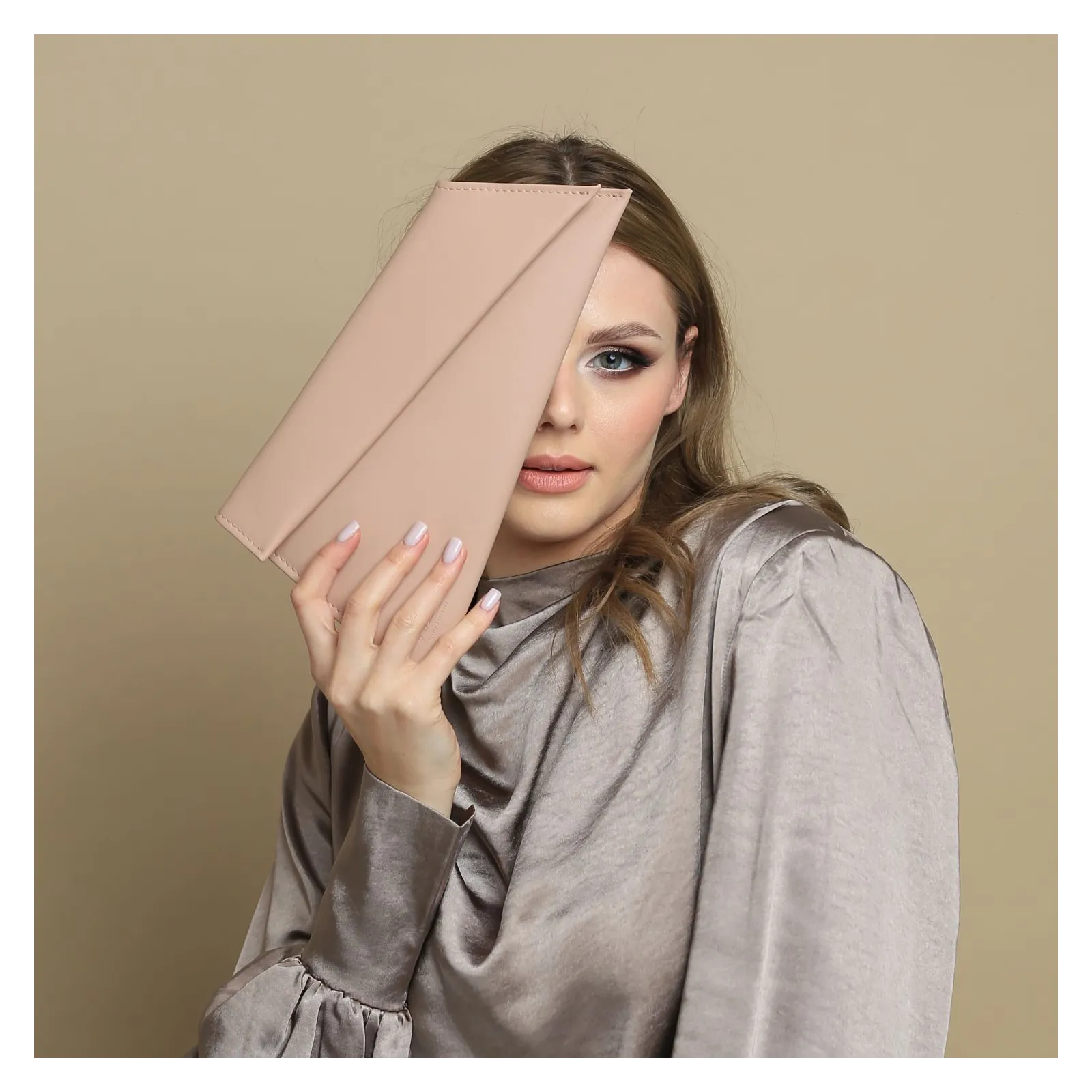 Torebka kopertówka na łańcuszku w kolorze nude różowym.