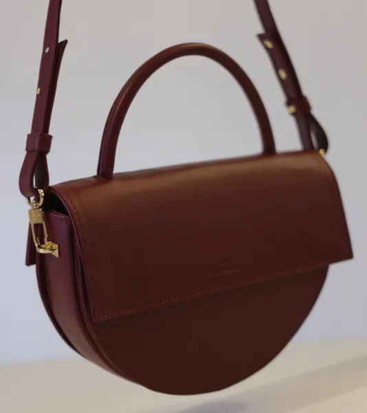 Bordowa torebka skórzana pólksiężyc.