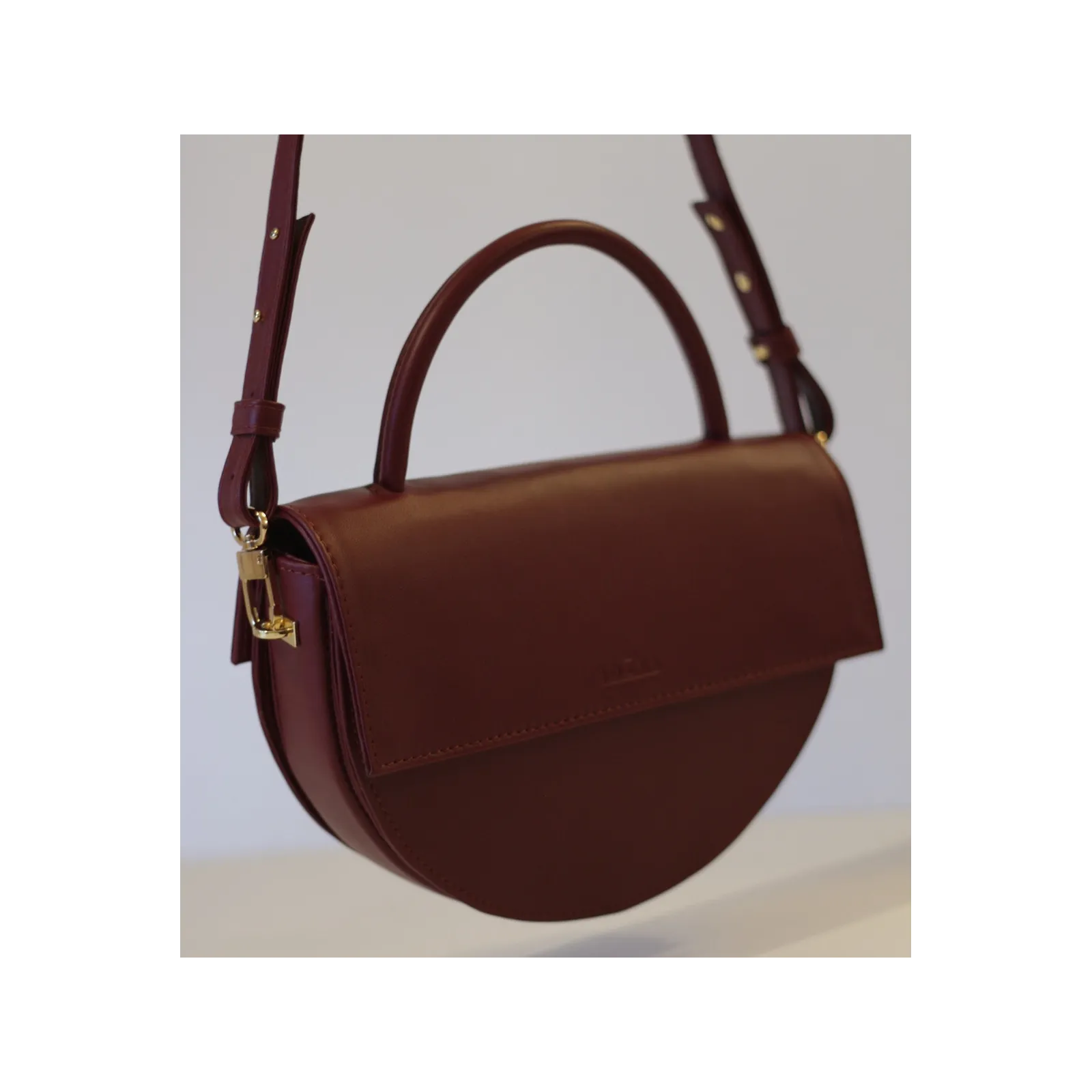 Bordowa torebka skórzana pólksiężyc.