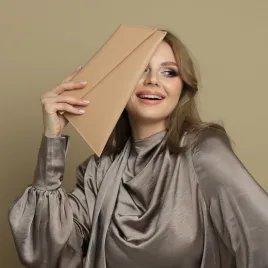 Torebka skórzana do ręki w beżowym kolorze.