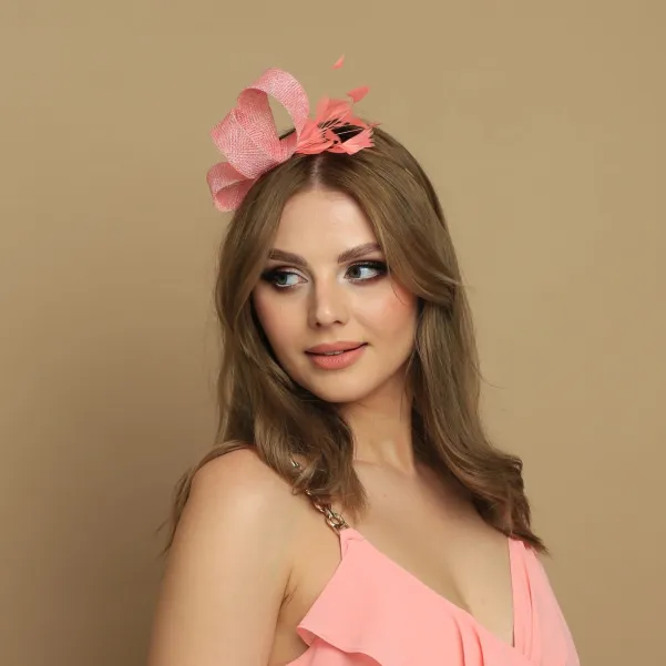 Brzoskwiniowy fascynator z delikatnymi piórami.