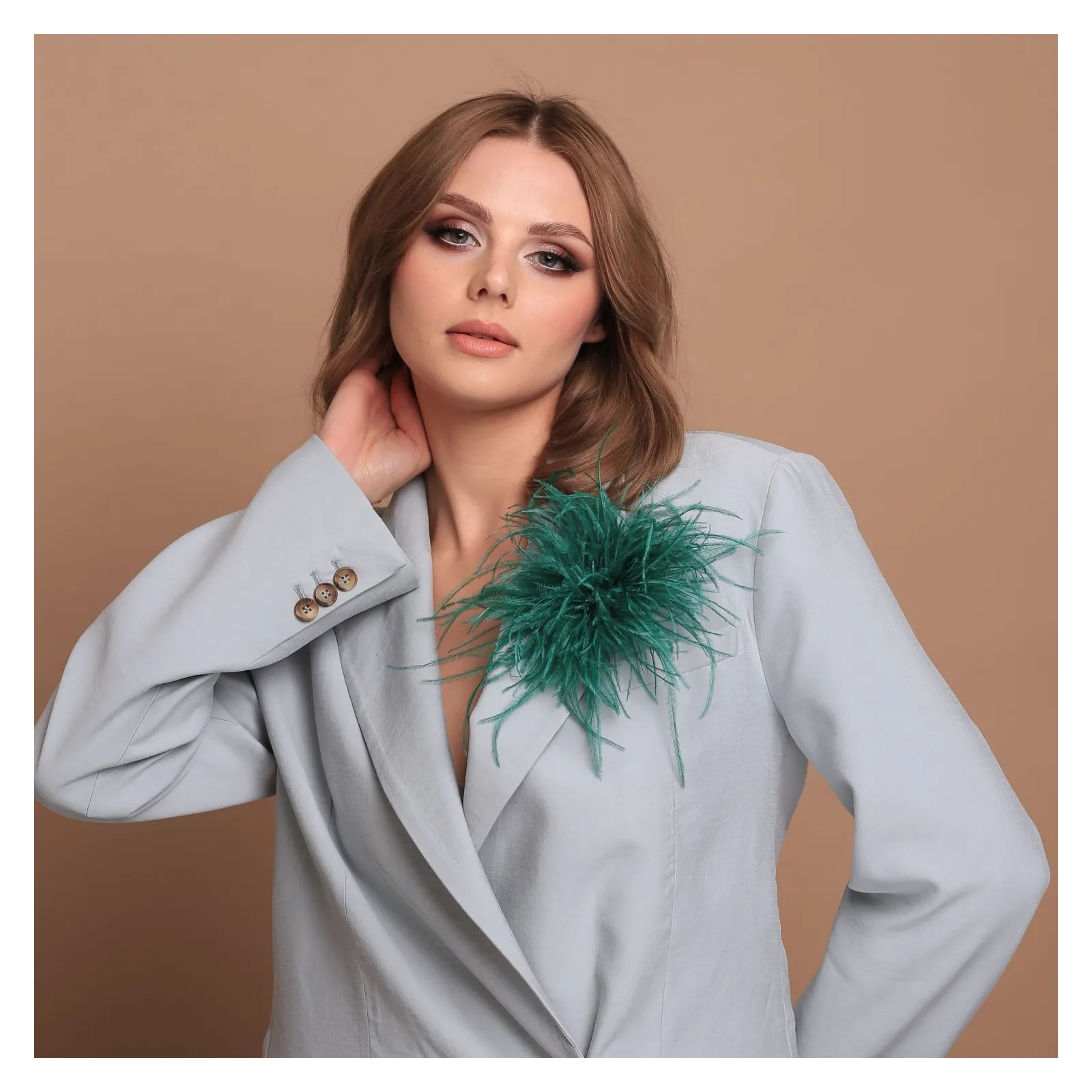 Ozdobna broszka z piórek zielona butelkowa.