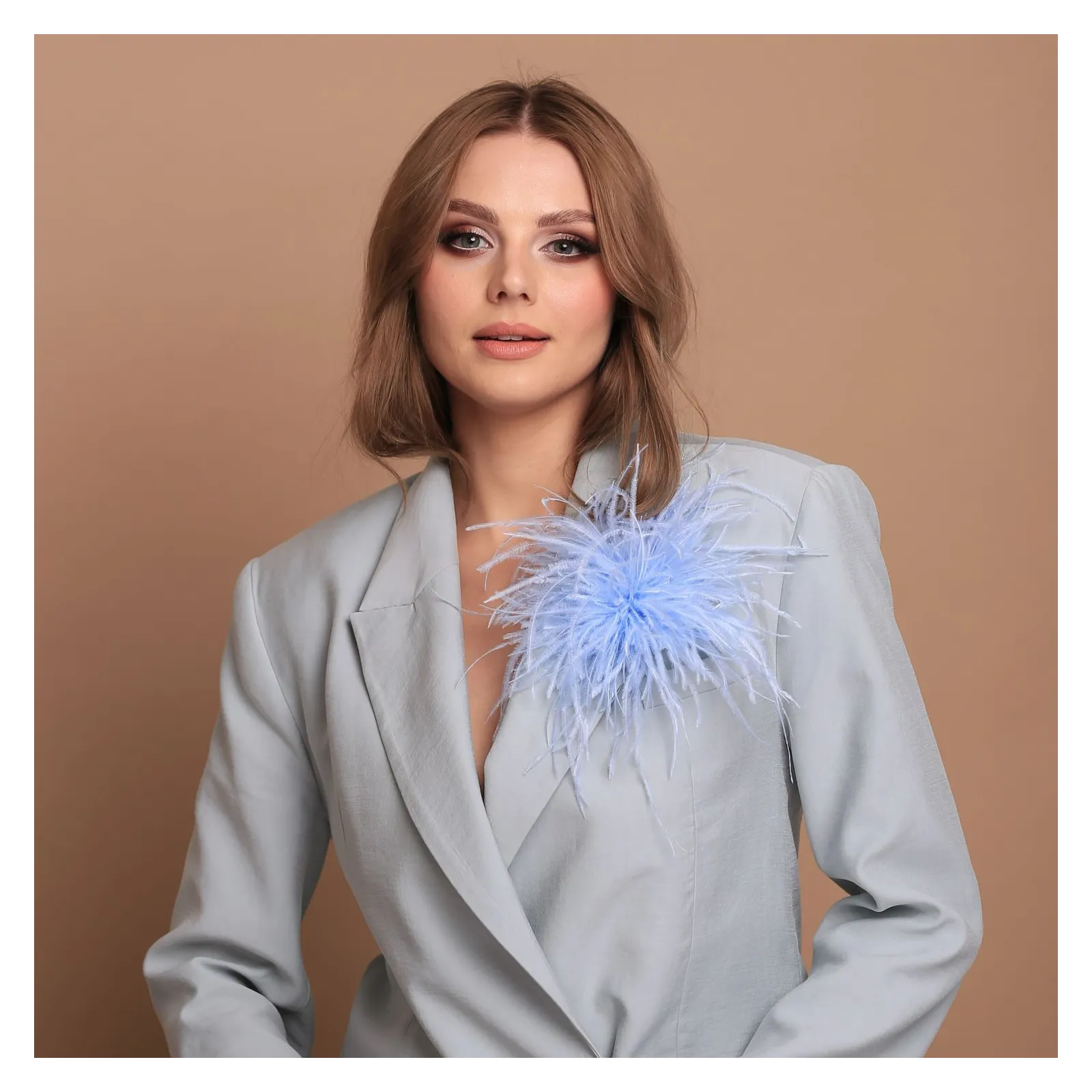 Broszka z błękitnymi strusimi piórkami.