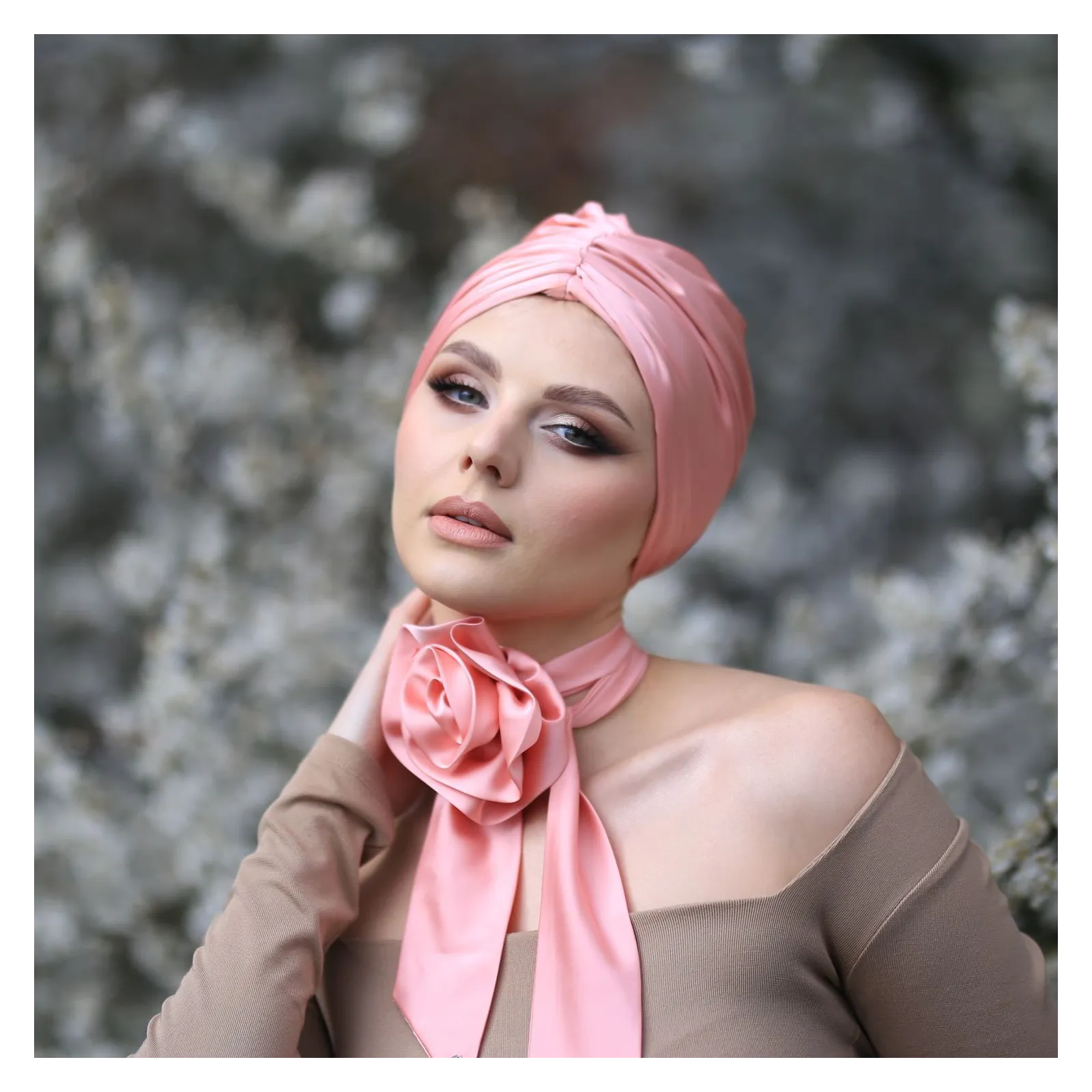 Apaszka twilly z brzoskwiniowym kwiatem na szyję.