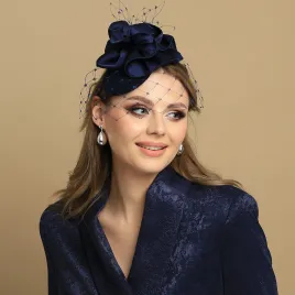 Granatowy mini toczek-fascynator z nieoczywistym kwiatem i woalką.