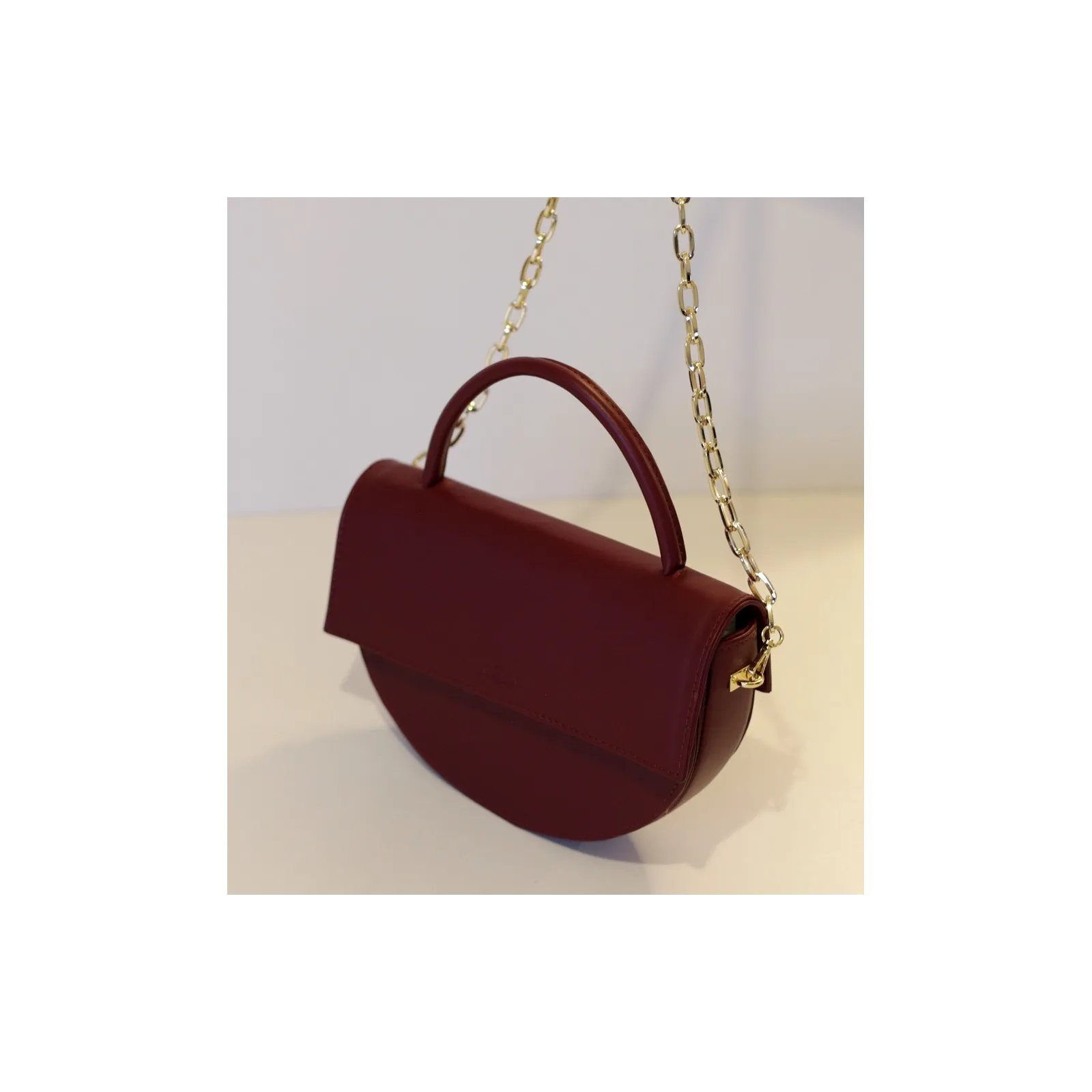 Bordowa torebka skórzana pólksiężyc.