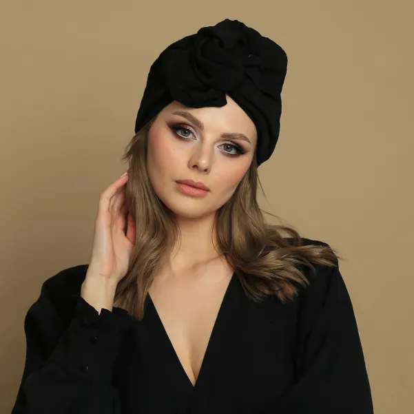 Czarny turban z dużą ozdobą z bawełnianej eleganckiej tkaniny.