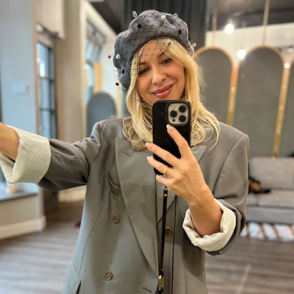 Szary beret z woalką w kropki.