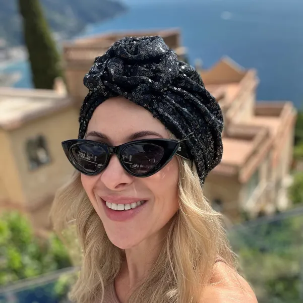 Turban damski w czarne cekiny z ozdobną różą.