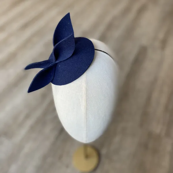 Granatowy mini kapelusik z gustowną ozdobą.