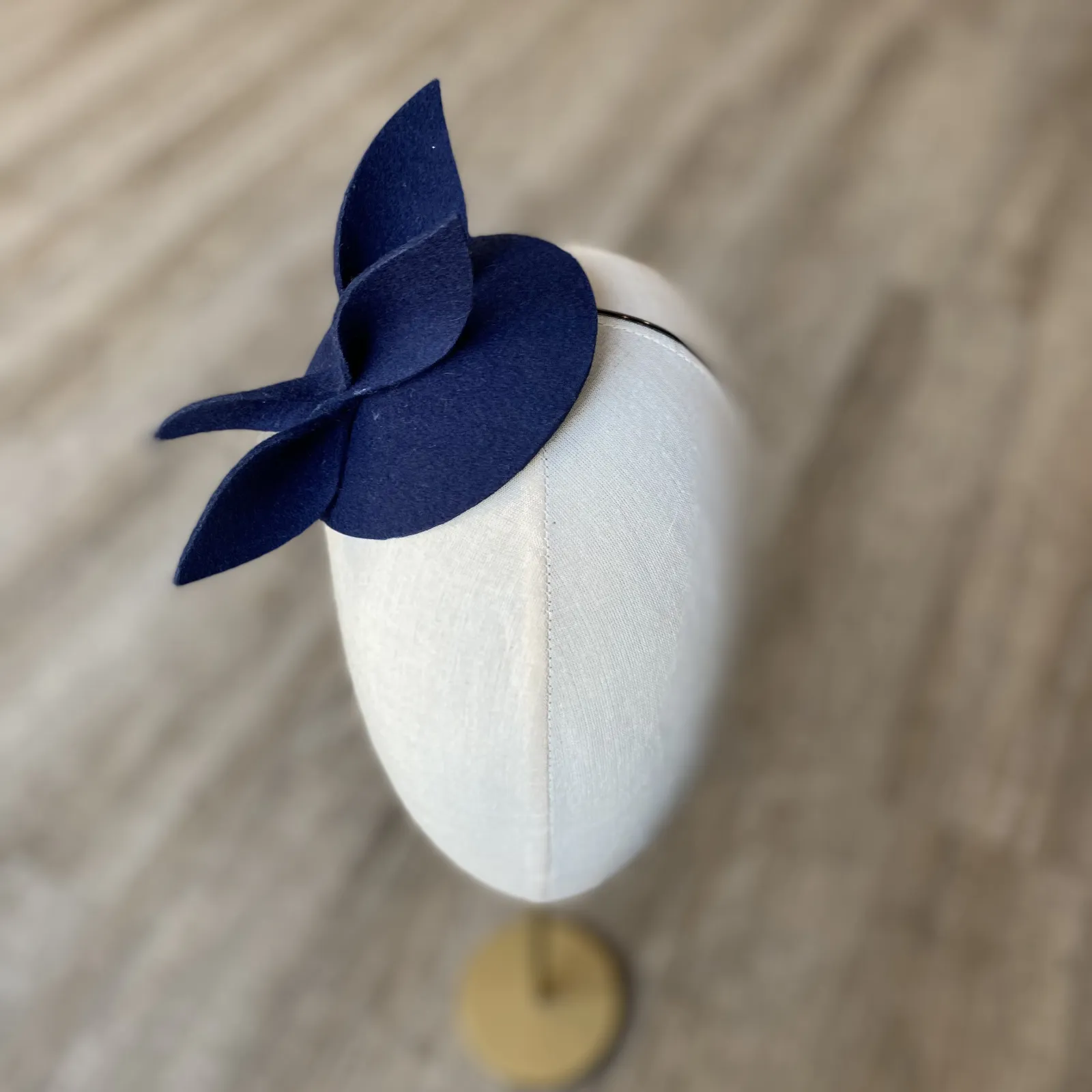 Granatowy mini kapelusik z gustowną ozdobą.