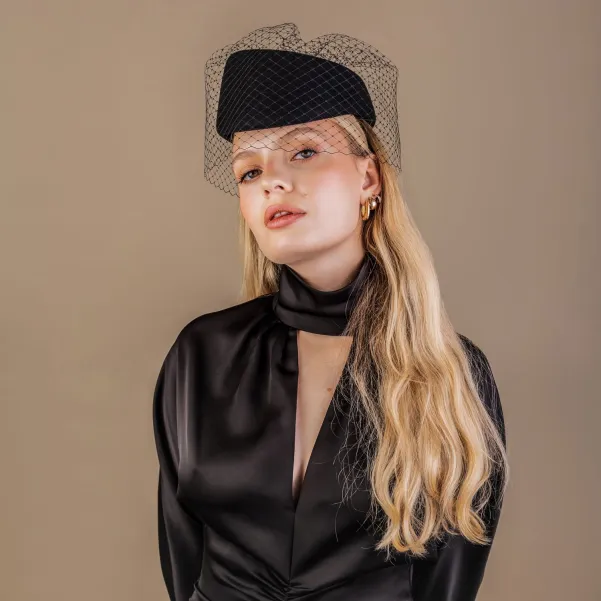Asymetryczny elegancki czarny toczek z woalką na oczy.