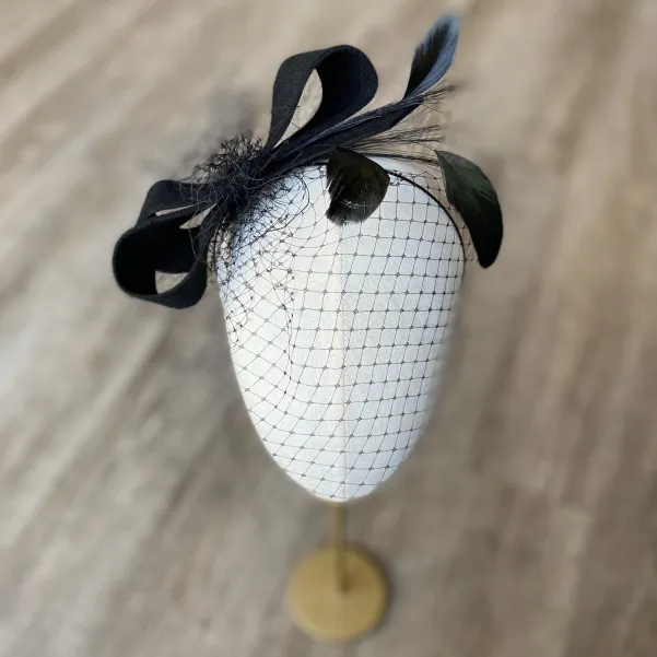 Czarna ficowa ozdoba do włosów z piórkami i woalką w kropki.