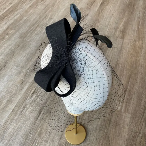 Czarna ficowa ozdoba do włosów z piórkami i woalką w kropki.