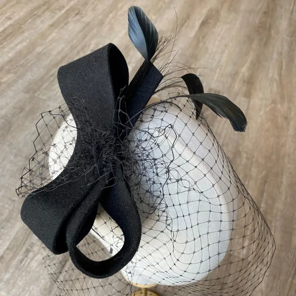 Czarna ficowa ozdoba do włosów z piórkami i woalką w kropki.