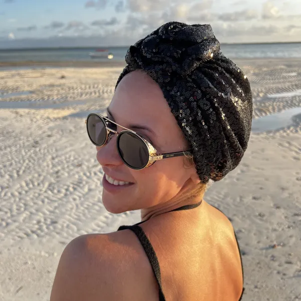 Turban damski w czarne cekiny z ozdobną różą.