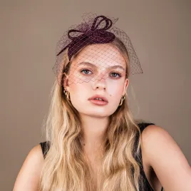 Bordowy toczek na głowę o oryginalnym kształcie z woalką.