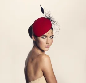 Czerwony toczek z woalką i z piórem