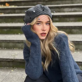 Szary beret z woalką w kropki.