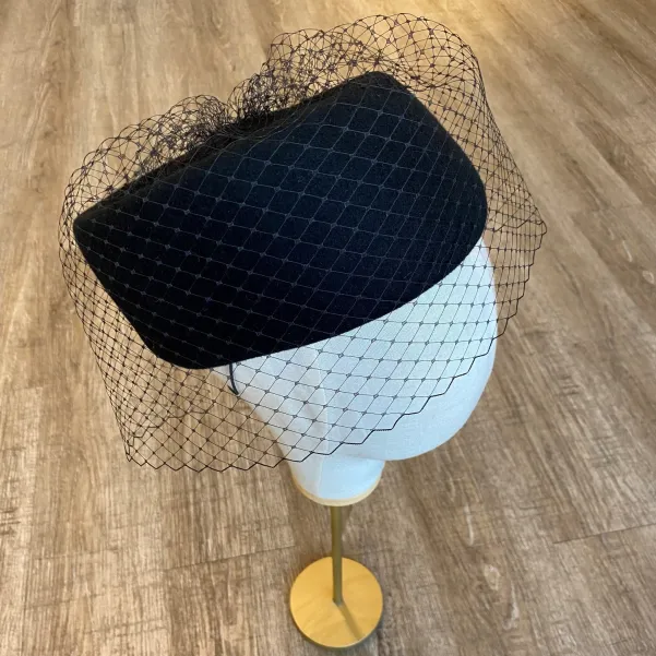 Asymetryczny elegancki czarny toczek z woalką na oczy.