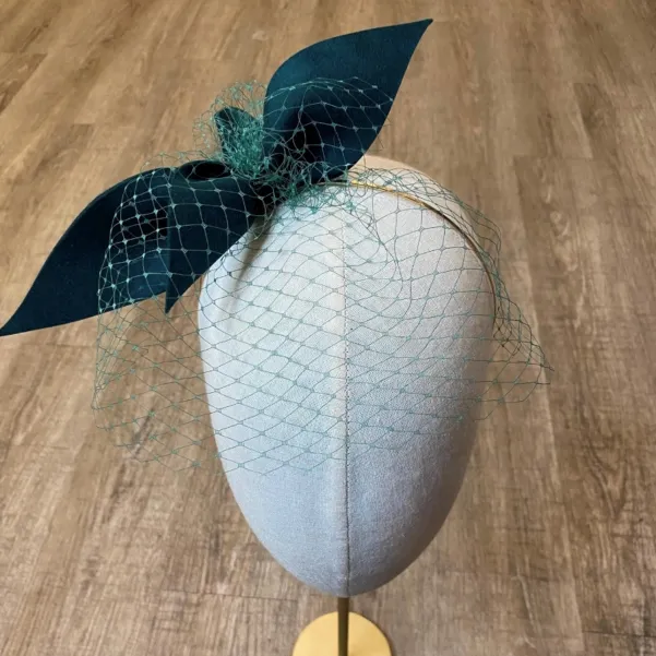 Zielony butelkowy fascynator z woalką.