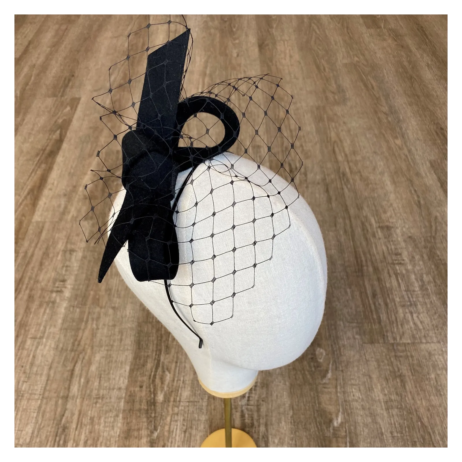 Czarny fascynator z woalką odwrócona kokarda.