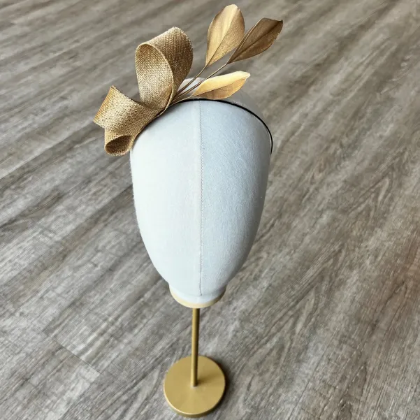 Delikatny fascynator na opasce w złotym kolorze. Delikatny fascynator na opasce w złotym kolorze.