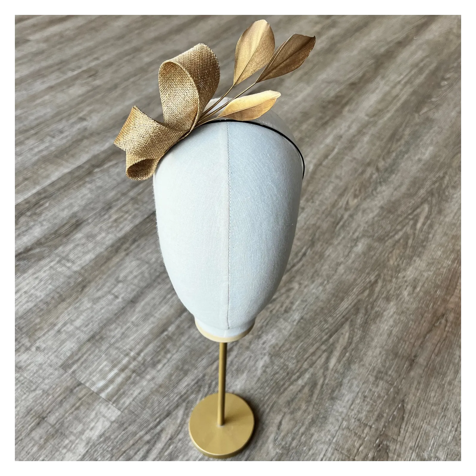 Delikatny fascynator na opasce w złotym kolorze.