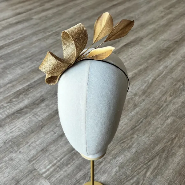 Delikatny fascynator na opasce w złotym kolorze. Delikatny fascynator na opasce w złotym kolorze.